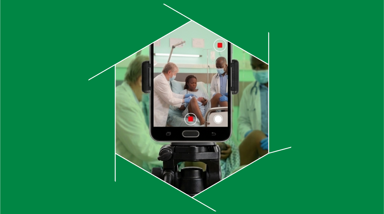 A phone on a tripod filming a mother, newborn and doctors in a clinic bay